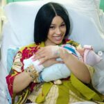 Cardi B lovingly holds her newborn daughter